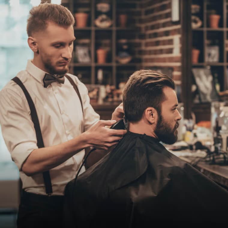 Een kapper die het haar van een klant in een moderne kapperszaak stylt, met de nadruk op de kappersservices op Salony.