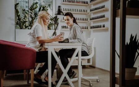 Close-up van een manicurist die nagellak aanbrengt op de nagels van een klant